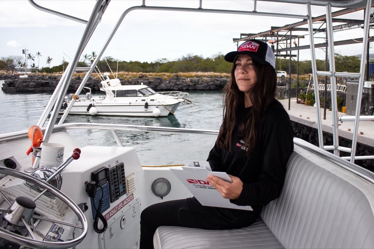Andi Cross reviewing field paperwork aboard a dive boat