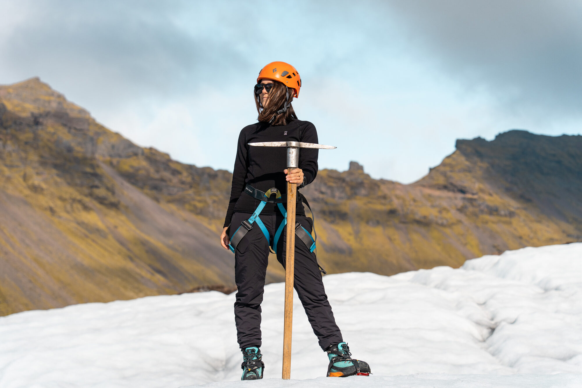 Andi Cross on glacier expedition in Iceland, Arctic Adventures, wearing orange helmet and holding ice axe